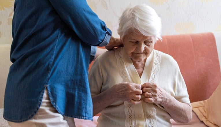 Les soins à domicile pour les personnes âgées consistent souvent en des soins personnels, comme l'aider à s'habiller.