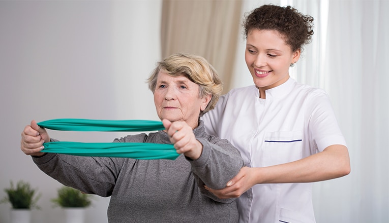 Madame fait des exercices avec un kinésithérapeute pour une hernie dorsale.